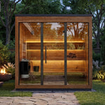 Leil Aris Lite outdoor sauna in a landscaped garden showing the wider front facade and lit interior