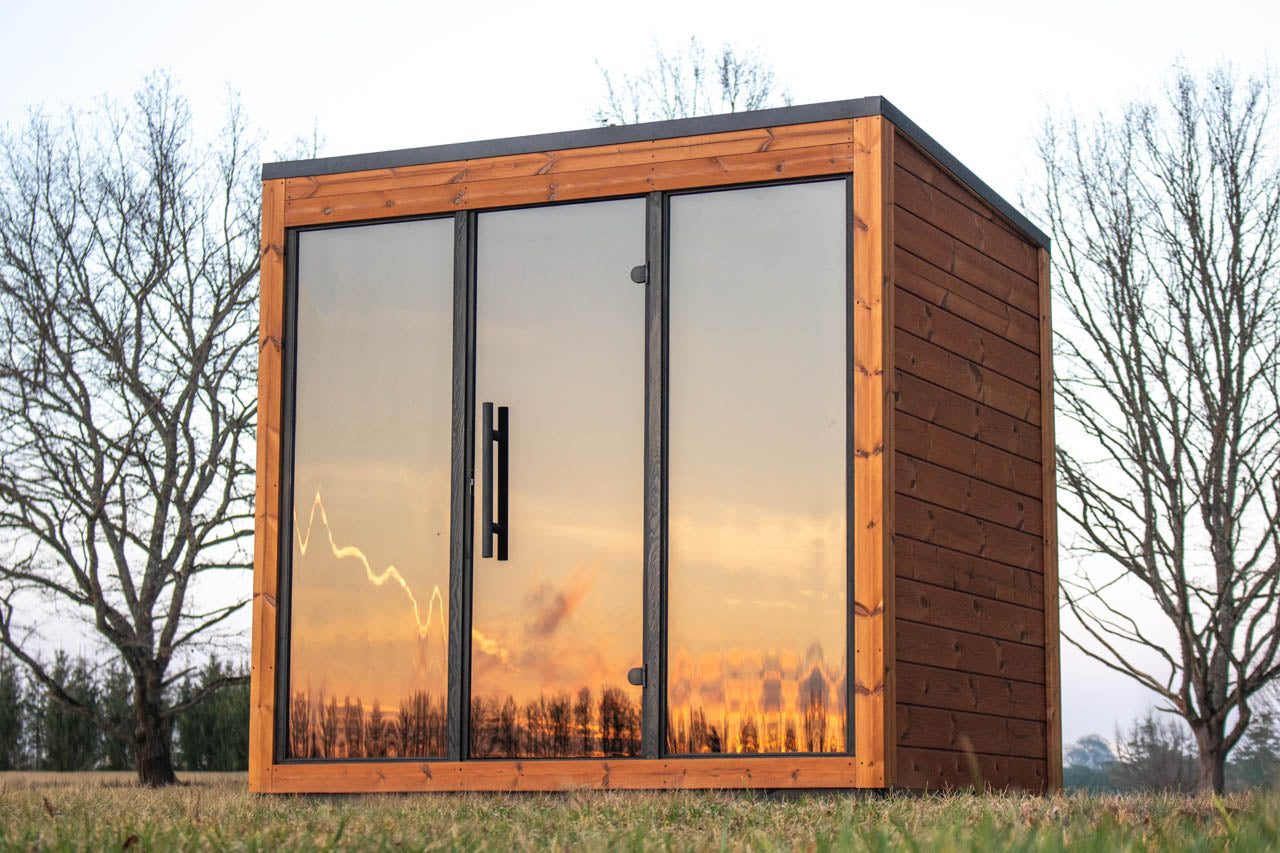 Rear and side view of the Leil Aris Lite sauna showing plain ThermoWood cladding and black roof trim
