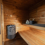Leil Aris Lite interior showing the sauna heater, lower bench and bronze glass door handles